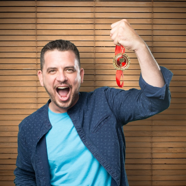 Foto grátis jovem vestindo uma roupa azul. com uma medalha de ouro.