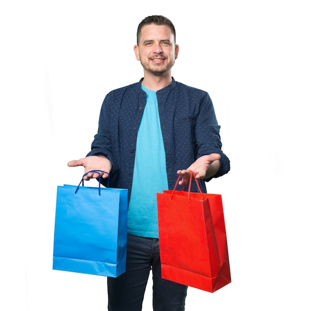 Jovem vestindo uma roupa azul. segurando sacolas de compras.