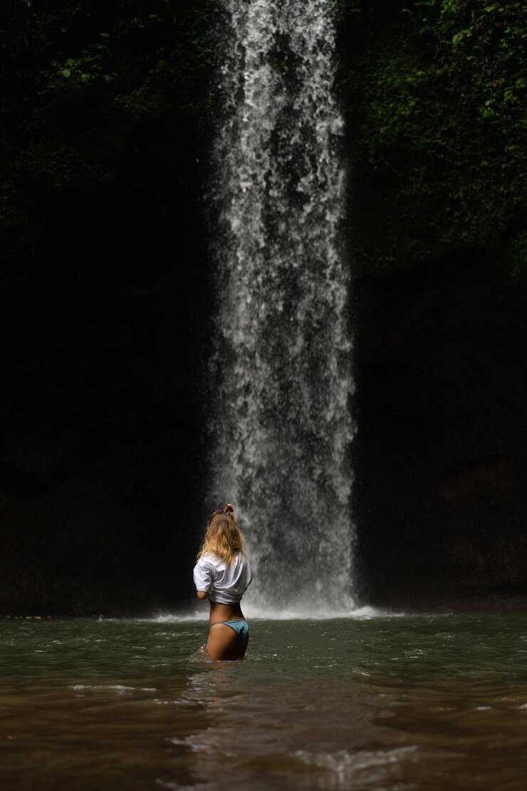 Foto grátis jovem viaja pela ilha tirando fotos em uma cachoeira