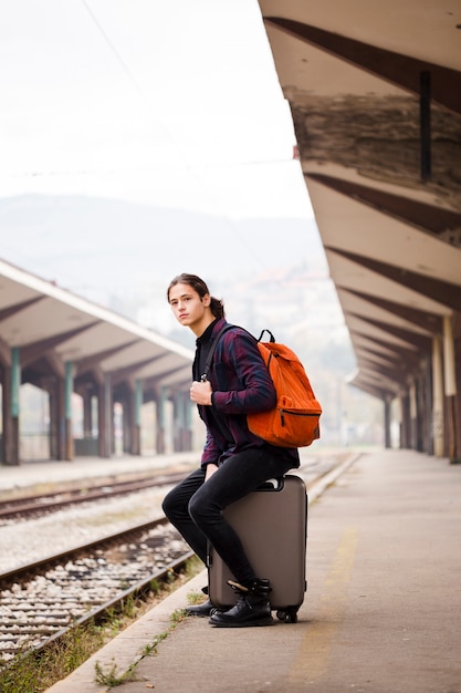 Foto grátis jovem viajante esperando na estação ferroviária