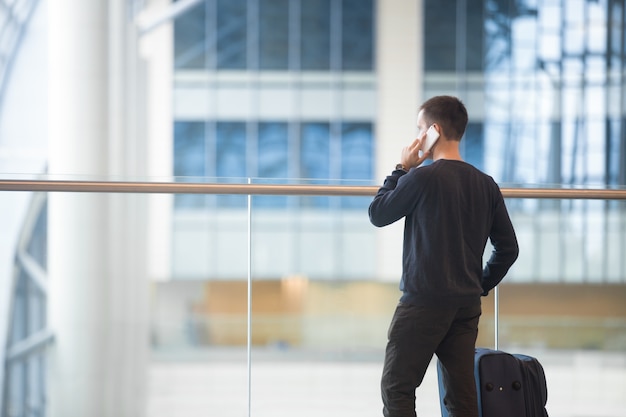 Foto grátis jovem viajante fazendo chamada no aeroporto