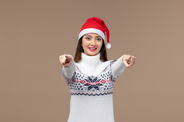 Jovem, vista frontal, com expressão sorridente em fundo marrom, emoção de férias natal