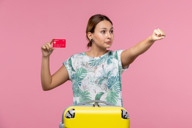 Jovem, vista frontal, segurando um cartão vermelho do banco na parede rosa, voo, avião, viagem, mulher, resto, mulher