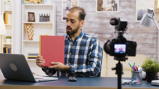 Jovem vlogger famoso gravando uma resenha de um livro para assinantes. estilo de vida vlogger.