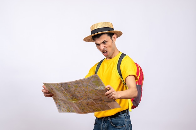 Jovem zangado de frente com uma mochila vermelha e uma camiseta amarela olhando para o mapa