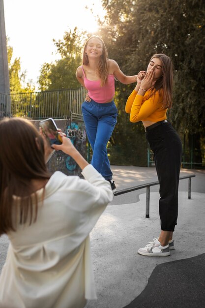 Jovens adolescentes gravando bobinas de si mesmas ao ar livre para mídias sociais