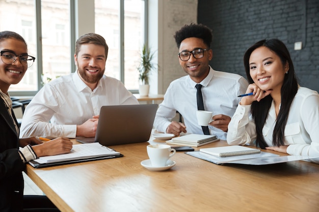 Jovens alegres colegas dentro de coworking