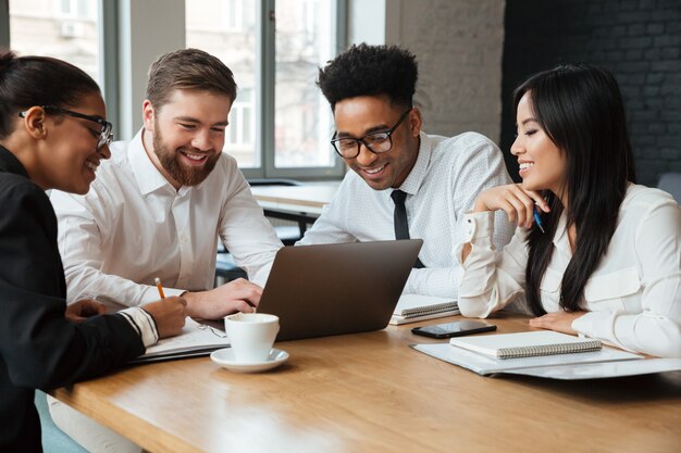 Jovens alegres colegas dentro de coworking