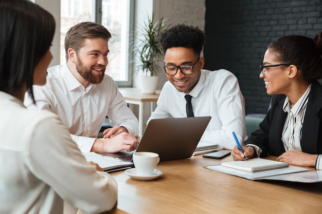 Jovens alegres colegas dentro de coworking