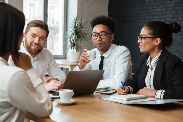 Jovens alegres colegas dentro de coworking