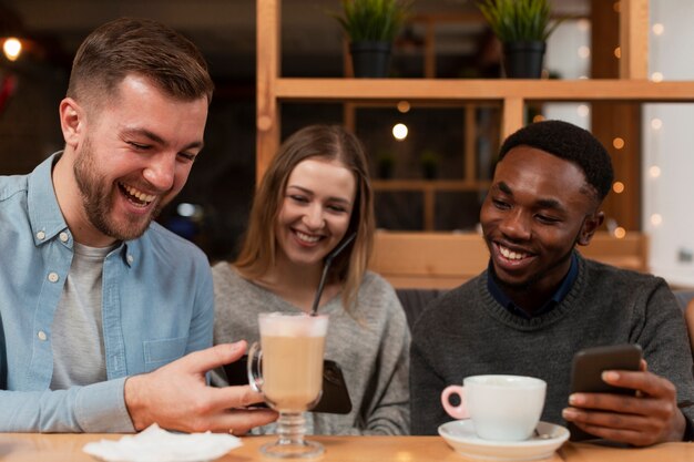 Jovens amigos olhando para telefones