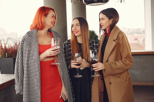 Jovens amigos rindo bebendo vinho rosé em um copo do lado de fora