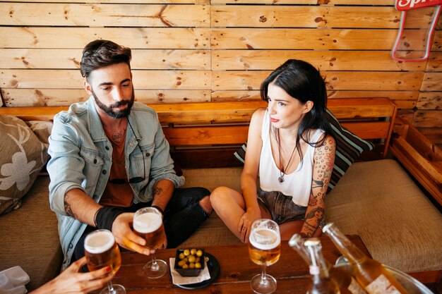 Jovens amigos sentados à mesa no bar