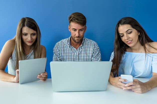 Jovens amigos trabalhando com dispositivos