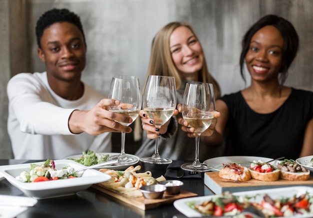 Foto grátis jovens bonitos que comem o vinho e o jantar