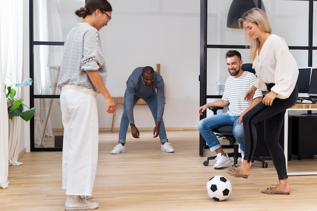 Foto grátis jovens brincando com bola no escritório