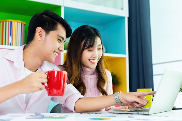 Jovens colegas bebendo bebidas durante o trabalho