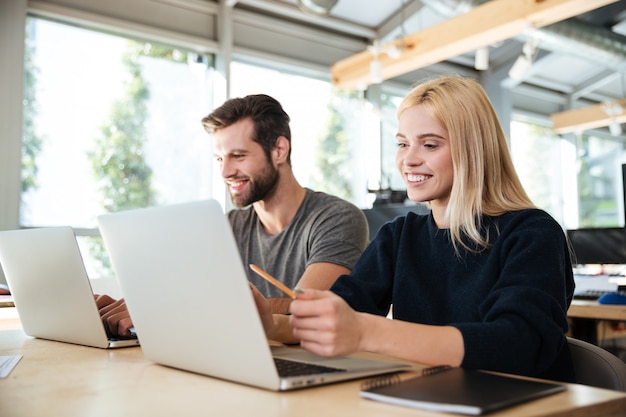 Foto grátis jovens colegas concentrados sentado no escritório de coworking