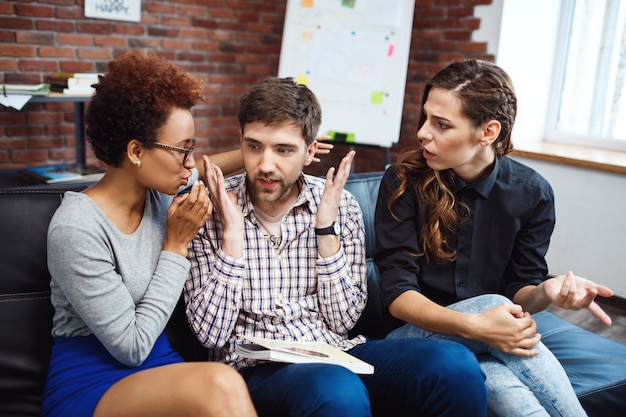 Jovens colegas se comunicando durante o freio de negócios no escritório.