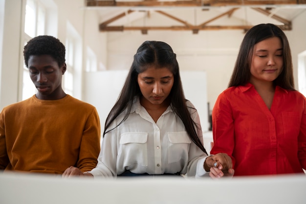 Jovens de tiro médio na igreja rezando