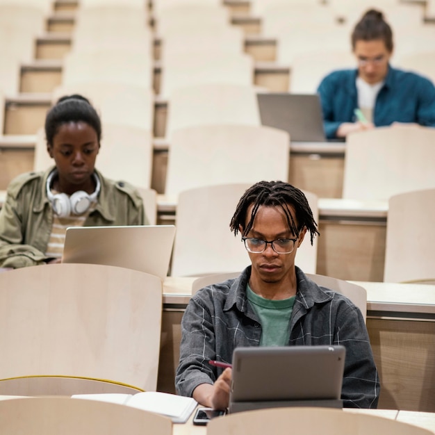 Jovens estudantes frequentando uma aula na universidade