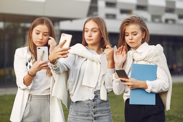 Jovens estudantes no campus de estudantes com seus telefones