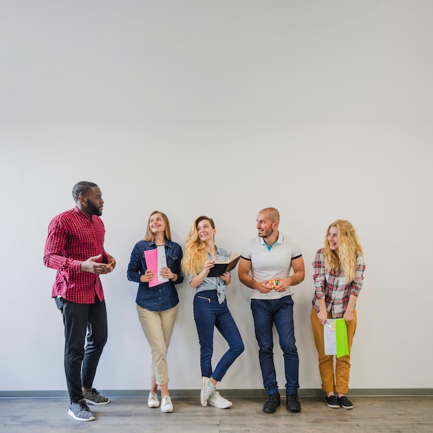 Jovens estudantes posando com blocos de anotações