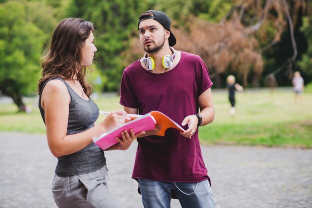 Jovens estudantes que se comunicam no parque