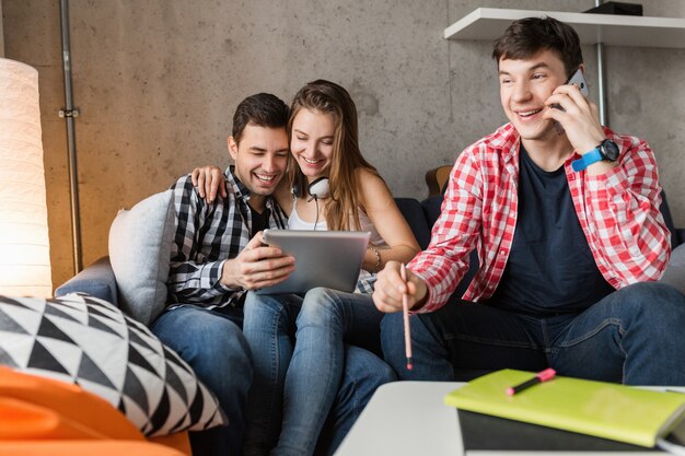 Jovens felizes usando tablet, alunos aprendendo, se divertindo, festa de amigos em casa, empresa hipster juntos, dois homens uma mulher, sorrindo, positivo, educação online, homem falando no telefone