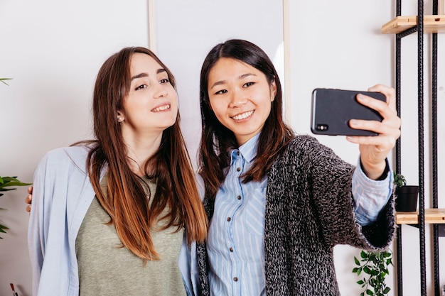 Foto grátis jovens garotas casuais levando selfie em casa