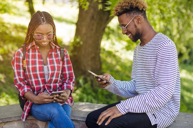 Foto grátis jovens negros assistindo telefones