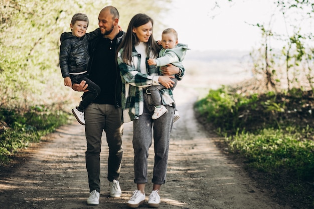 Jovens pais com seus filhos na floresta