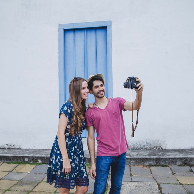 Jovens turistas que tomam selfie com câmera