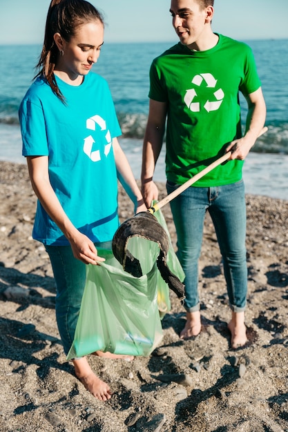 Jovens voluntários coletando lixo na praia