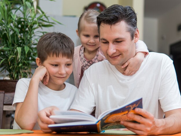 Juntos, família com irmãos, lendo um livro