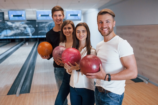 Juventude de boa aparência. Amigos alegres se divertem no clube de boliche nos fins de semana