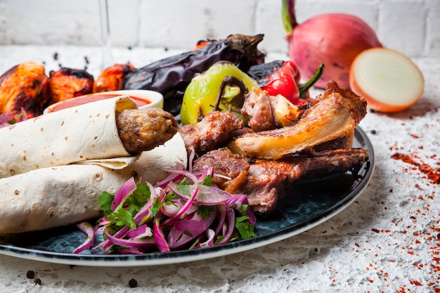 kebab variado com legumes fritos e cebola em prato redondo