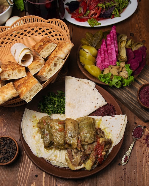 Foto grátis kelem dolmasi, folhas de repolho recheadas com carne e arroz, com guisado de carne com legumes em panela.