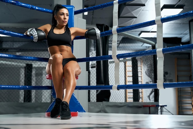 Foto grátis kickboxer feminino descansando no canto do ringue