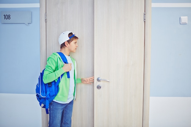 Foto grátis kid espreita para fora através da porta