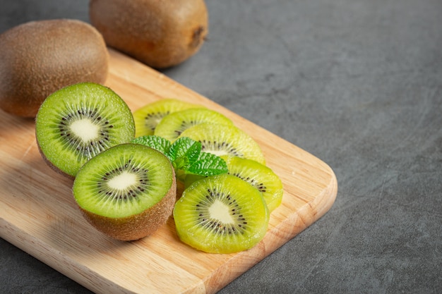 Foto grátis kiwi fresco, cortado ao meio, colocado em uma tábua de madeira