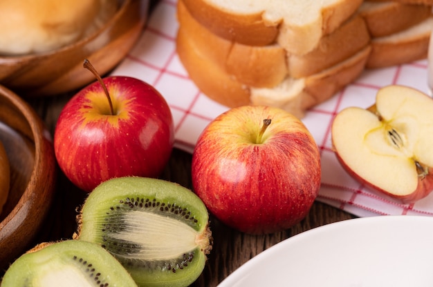 Kiwi, maçãs e pão na mesa