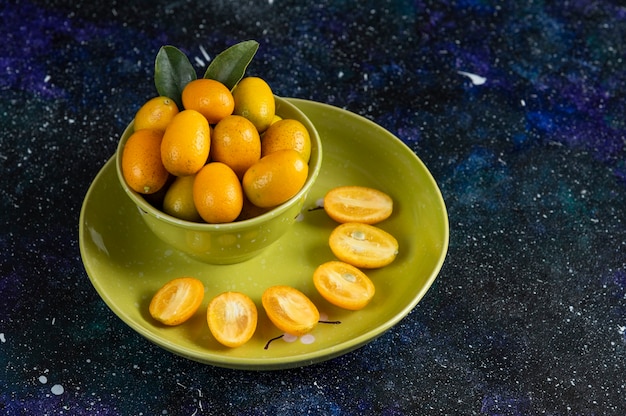 Kumquats orgânicos frescos inteiros ou meio cortados