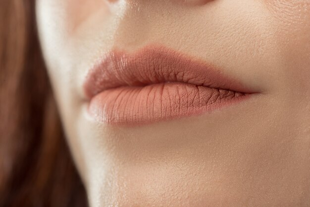 Lábios perfeitos. Sorriso de mulher jovem de beleza. Lábio carnudo natural. Detalhe de close