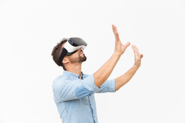 Lado do barbudo usando óculos de realidade virtual, tocando o ar