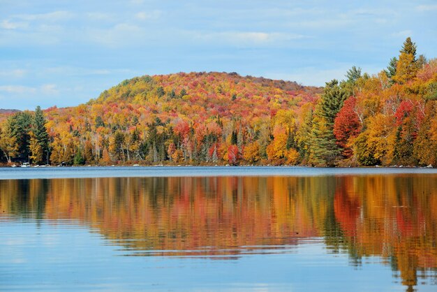 Lago com folhagem de outono e montanhas com reflexo em New England Stowe