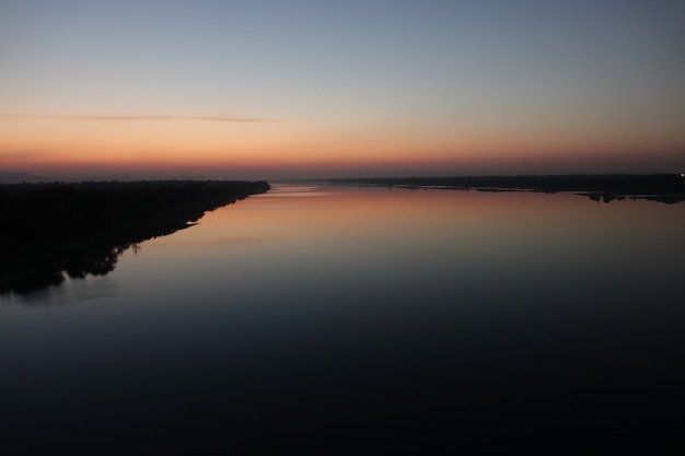 Lago com praia ao pôr do sol