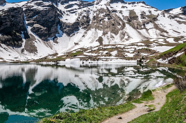 Lago Lac Lioson na Suíça cercado por montanhas e neve