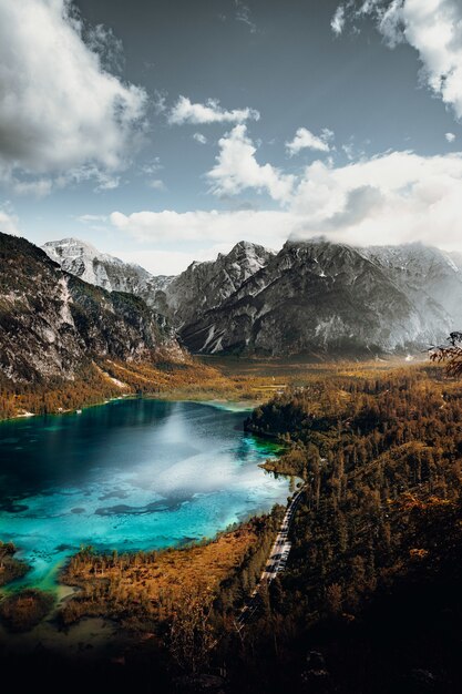 Lago no meio das montanhas sob nuvens brancas e céu azul durante o dia