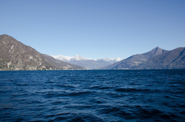 Lago panorâmico com montanhas no horizonte e céu azul